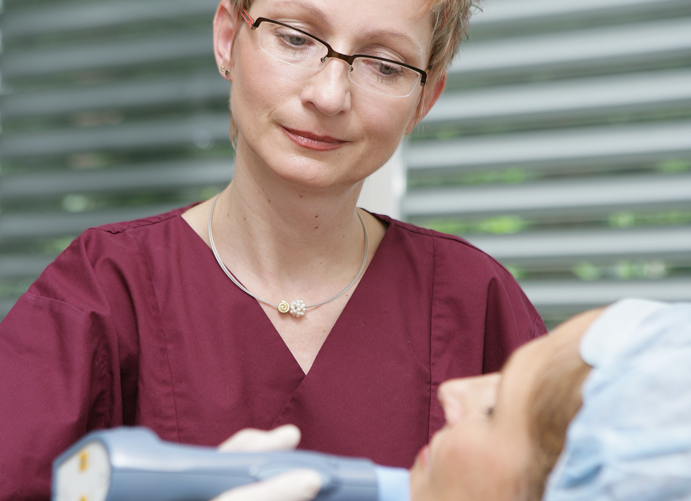 Dr. Birgit Buxmeyer f&auml;hrt zur Faltenbehandlung mit dem Thermage-Handst&uuml;ck &uuml;ber die Gesichtshaut der Patientin